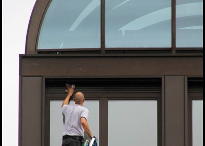 Man on ladder cleaning municipal or hosptial windows.